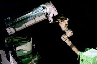 L'astronaute de l'Agence spatiale européenne Thomas Pesquet, monté sur le bras robotique Canadarm2, manœuvre le premier panneau solaire de la Station spatiale internationale (iROSA) à l'extérieur de la Station spatiale internationale le 16 juin 2021.