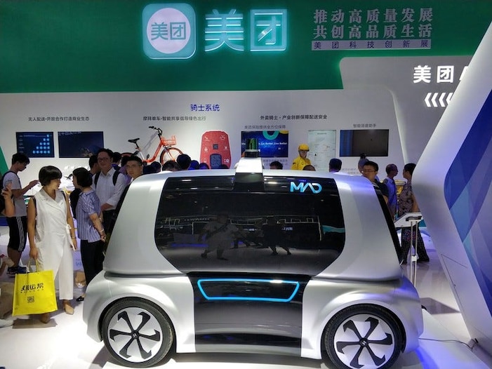 Des visiteurs regardent un véhicule de livraison autonome Meituan (MAD) de la plateforme de livraison de nourriture chinoise Meituan-Dianping, lors de la première Smart China Expo à Chongqing, en Chine, le 23 août 2018. Photo prise le 23 août 2018. REUTERS / Stringer