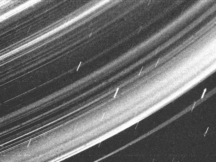 L'image granuleuse en noir et blanc montre un gros plan des anneaux d'Uranus.